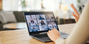 Person joining virtual group therapy on laptop with multiple participants, representing virtual IOP and online support at Rooted Stillness in Newport Beach.