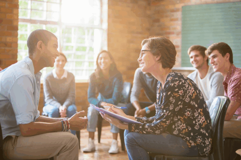 Therapist leading group counseling session with clients, representing supportive mental health and addiction treatment at Rooted Stillness in Newport Beach