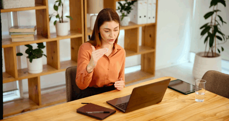 Woman participating in online therapy session on laptop representing virtual IOP and remote mental health treatment at Rooted Stillness in Newport Beach.