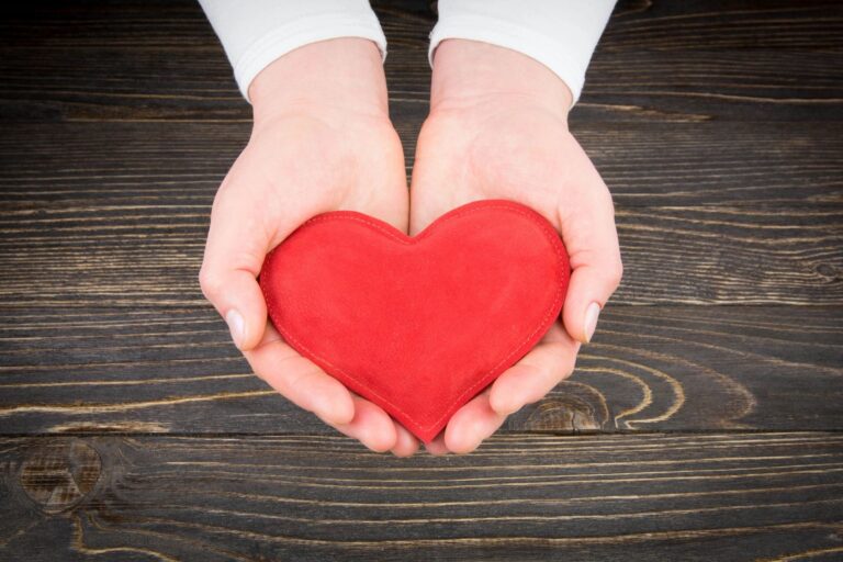 Hands holding a red heart shape